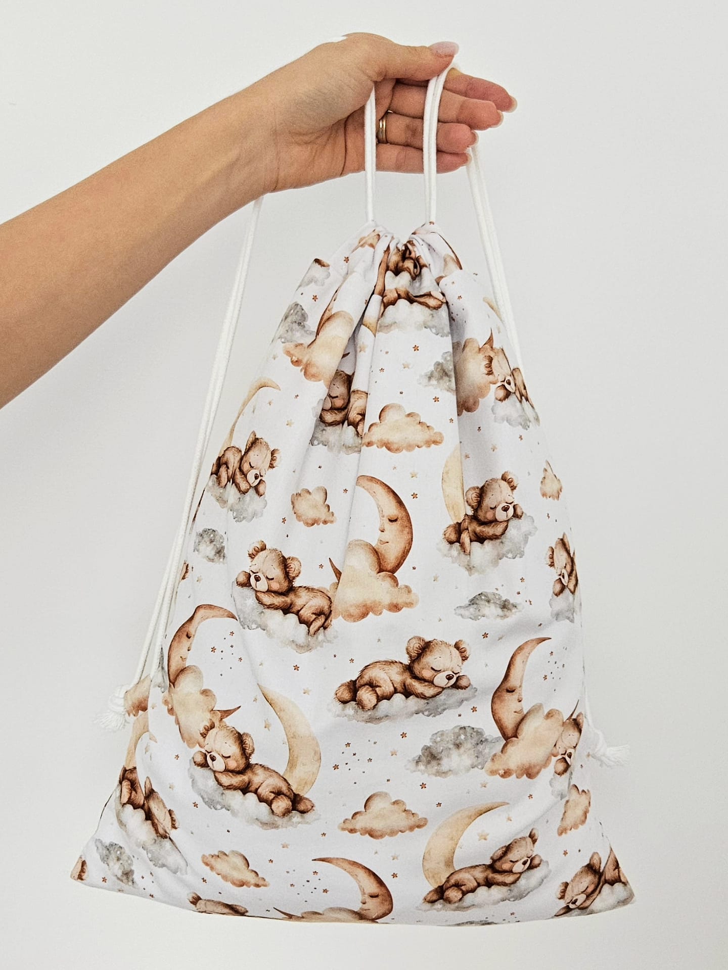 Rucsac handmade din bumbac cu imprimeu cu ursuleti adormiti pe nori si luna, tinut in mana.