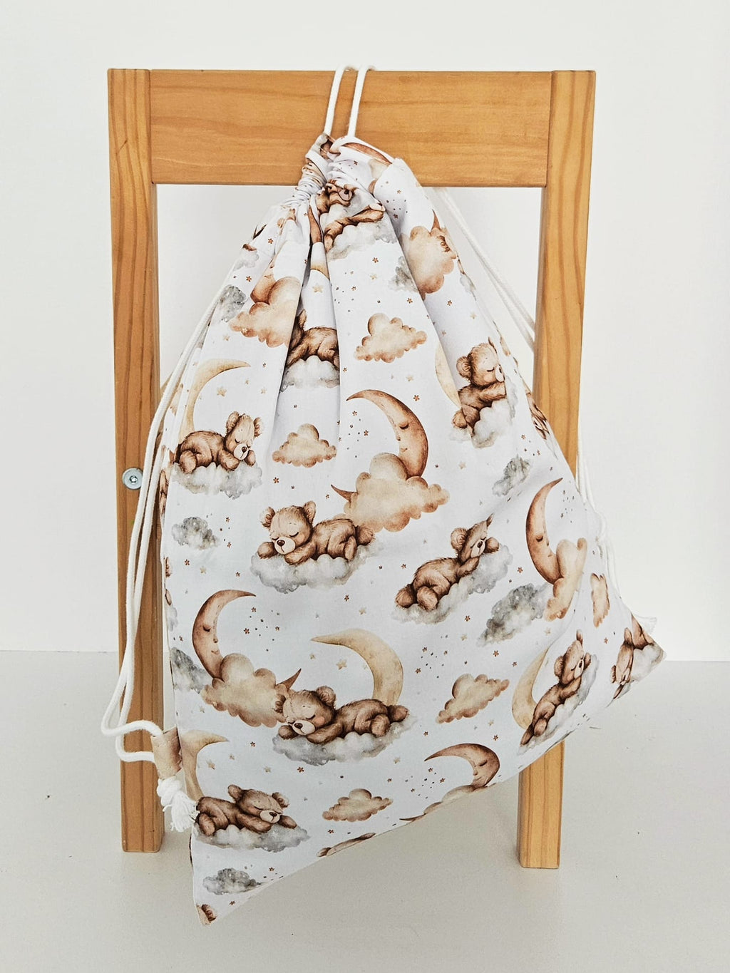 Rucsac handmade din bumbac cu imprimeu cu ursuleti adormiti pe nori si luna, tinut in mana.