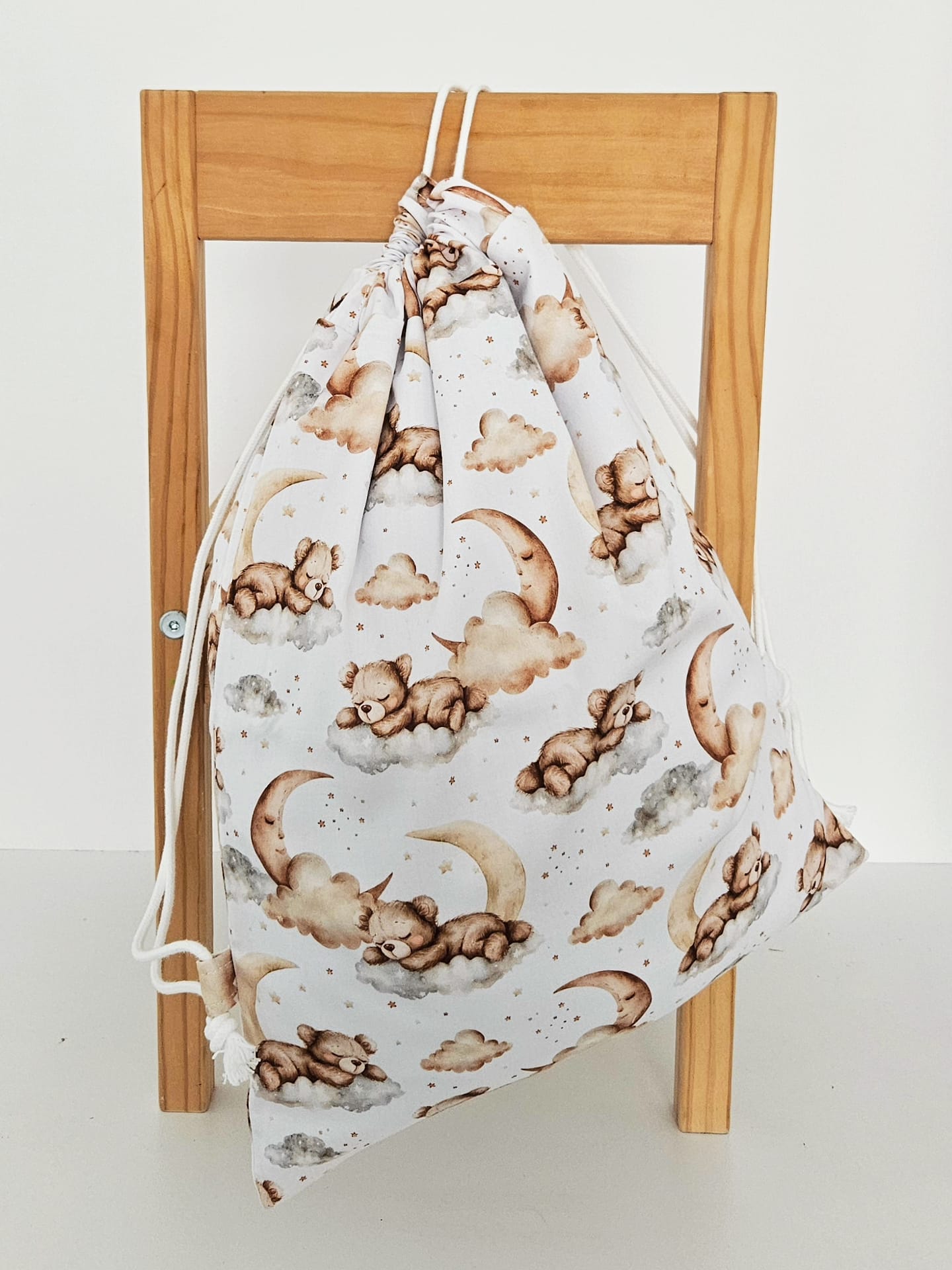 Rucsac handmade din bumbac cu imprimeu cu ursuleti adormiti pe nori si luna, tinut in mana.