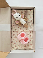 Set cadou Judy Ecru pentru nou-nascuti cu muselina, prosopel din muselina, jucarie crosetata fluturas si botosei roz, aranjate elegant in cutie.
